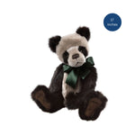 Plush panda bear with a green bow tie on a white background