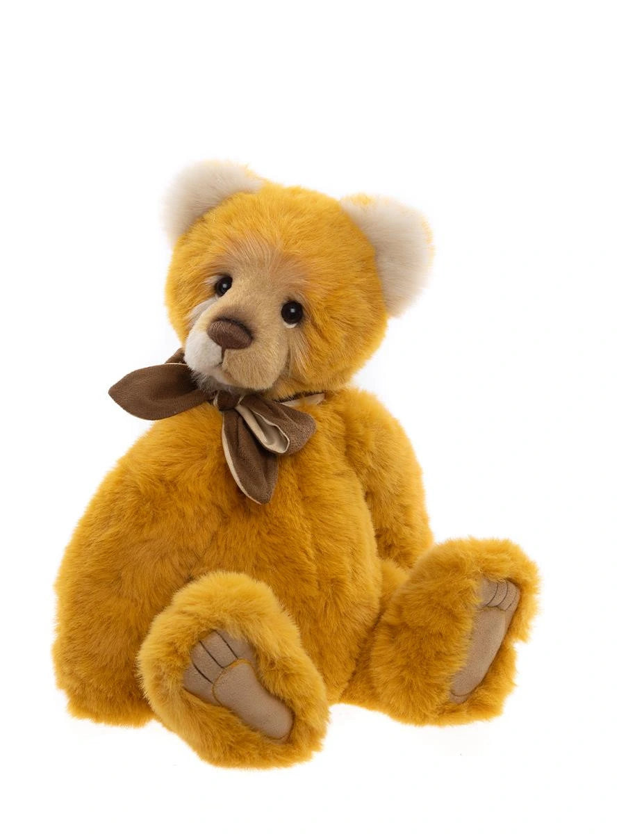 Yellow teddy bear with a brown bow tie on a white background
