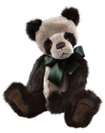 Stuffed panda bear with a green bow tie on a plain background