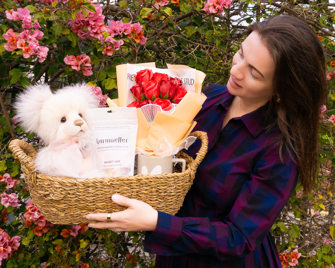 Teddy bear gift basket wrapped with tissue, ribbon, and a gift card